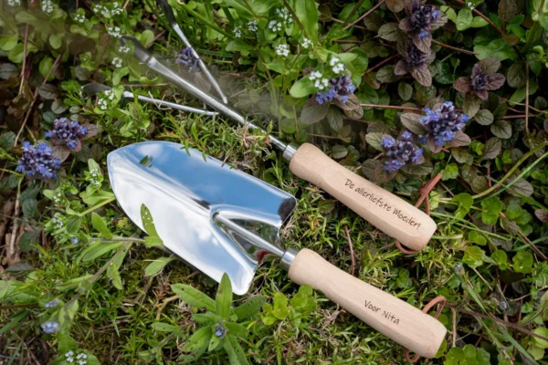 Gegraveerd tuingereedschap tussen de bloemen, gemaakt door Puntgaaf made personal